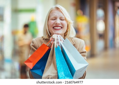 Excited Woman Having Fun Shopping And Holding Bags While Looking At The Camera Smiling. Beautiful Woman Holding Shopping Bags And Smiling. Young Beautiful Girl Is Shopping In The Mall 