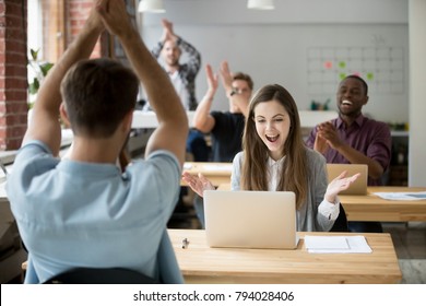 Excited woman looking at laptop screen surprised by good online news win achievement, corporate team colleagues congratulating coworker with business success clapping hands in coworking shared office - Powered by Shutterstock