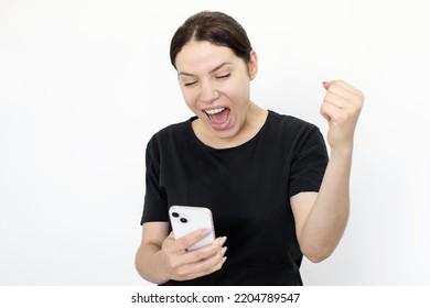 Excited Woman Looking At Phone And Celebrating Victory. Proud Woman Receiving Good News, Looking Smartphone Screen With Open Mouth And Gesturing. Success, Portrait, Emotion, Technology Concept