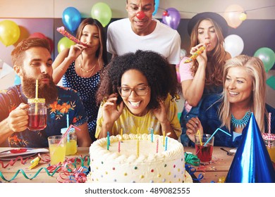 Excited woman ready to blow out candles on white frosting cake on table at birthday party with happy friends - Shutterstock ID 489082555
