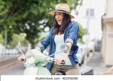 Excited Woman Riding Moped In City