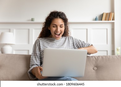 Excited woman sit on couch put computer on laps look at device screen read unbelievable offer, received new job incredible opportunity, gambling on-line auction winner. Cool apps, modern tech concept