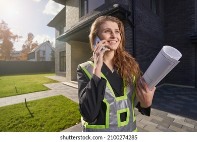 Excited Woman Site Engineer With Drawings Talking On Phone