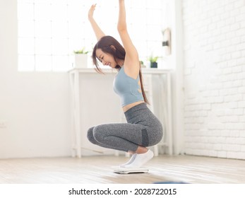 Excited Woman Sitting On Scales At Home, Overjoyed With Success Of Weight Loss.