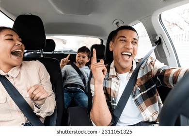 Excited young african american family singing riding new car and having fun enjoying summer road trip on vacation - Shutterstock ID 2311051325