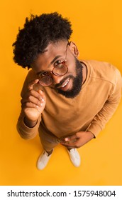 Excited Young African Man In Glasses Looking At Camera, Full Body Over Orange Background, Top View