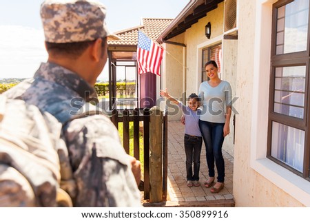 excited young american family welcoming military father returning home