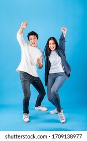 Excited Young Asian Couple Man And Woman Happy Celebrate Success Over Blue Background, Winner Concept