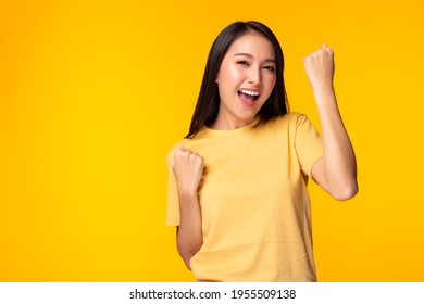 Excited young asian female with raised hands celebrating success Portrait cheerful positive asian woman with raised hands and fists open mouth Girl get happy, enjoy life yellow background, copy space - Shutterstock ID 1955509138
