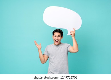 Excited Young Asian Man With Empty Speech Bubble Studio Shot Isolated On Light Blue Background