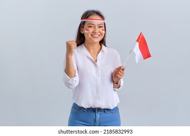 Excited young Asian woman celebrate Indonesian independence day holding the Indonesian flag isolated on white background - Shutterstock ID 2185832993