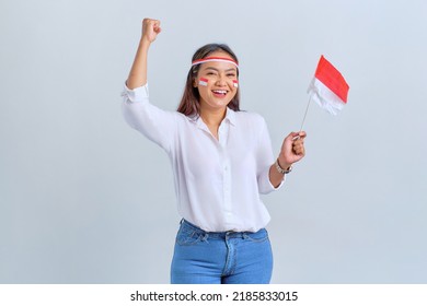 Excited young Asian woman celebrate Indonesian independence day holding the Indonesian flag isolated on white background