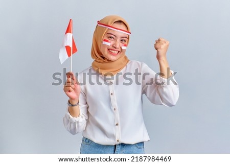 Excited young Asian woman celebrating Indonesian independence day with Indonesian flag isolated on white background