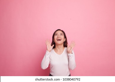 Excited Young Asian Woman Look Up On Pink Background