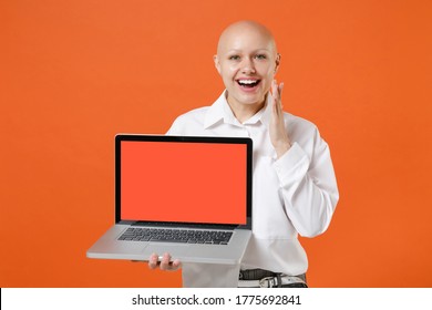 Excited Young Bald Business Woman In White Shirt Isolated On Orange Background. Achievement Career Wealth Business Concept. Mock Up Copy Space. Working On Laptop Pc Computer With Blank Empty Screen