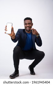 excited young black business man showing his phone screen to the camera and pointing to it