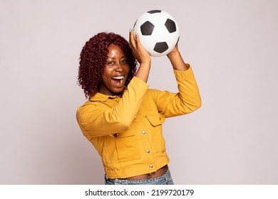 excited young black lady playing with a football - Shutterstock ID 2199720179