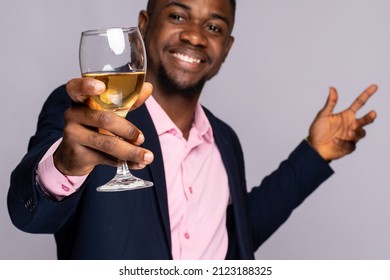 excited young black man raises a glass of wine - Shutterstock ID 2123188325