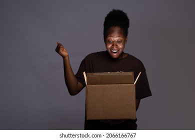 Excited Young Black Woman Opening A Box