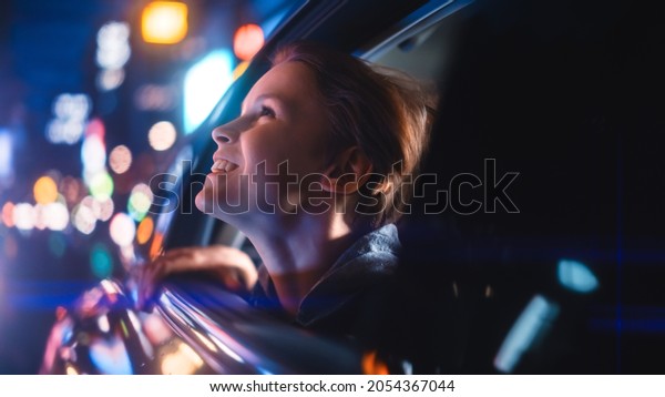 Excited Young Boy is\
Sitting on Backseat of a Car, Commuting Home at Night. Looking Out\
of the Window with Amazement of How Beautiful is the City Street\
with Working Neon\
Signs.