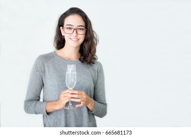 Excited young businesswoman drinking champagne