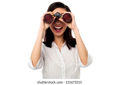 Excited young businesswoman looking through binoculars.