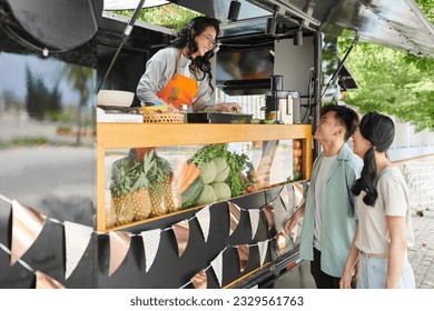 Excited young couple ordering sandwiches in food truck - Powered by Shutterstock