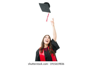 Excited Young Female Graduate Throwing Her Graduation Cap In The Air And Celebrating After Getting A University Diploma