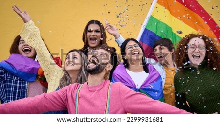 Excited young friends of LGBT community celebrating gay pride day festival. Group of diverse joyful cheerful people having fun together under shower of confetti. Generation z and social event. 