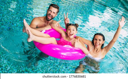 Excited And Young Happy Family On Vacation In The Spa Hotel Are Relaxing And Have Fun In The Swimming Pool. Summer Rest