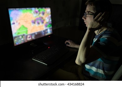 Excited young man with headphones playing computer games in dark room - Shutterstock ID 434168824