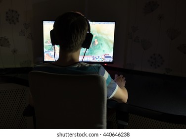 Excited Young Man With Headphones Playing Computer Games In Dark Room