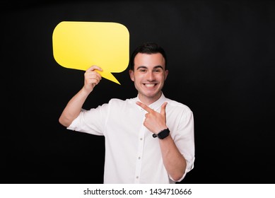 Excited Young Man Pointing At A Yellow Bubble Speech. Say Something Or Leave Comment.