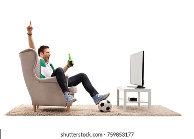 Excited Young Man With A Scarf And A Bottle Of Beer Watching Football On Television And Pointing Up Isolated On White Background