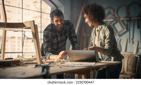 Excited Young Man and Woman Using Laptop Computer, Discussing a Successful Project in a Carpentry Studio. Furniture Designers High Five and Celebrate Receiving a Big Business Opportunity.