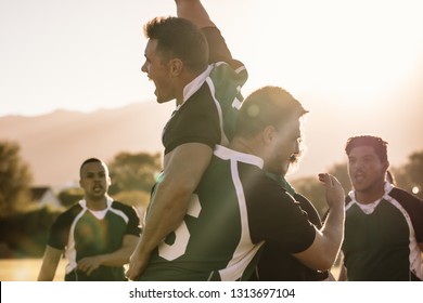 Excited Young Rugby Players Celebrating A Win At The Sports Field. Rugby Team Enjoying After The Victory.