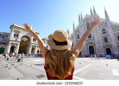 Excited young woman with arms raised in Milan Cathedral Square, Italy