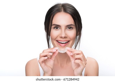 Excited Young Woman Holding Clear Aligner
