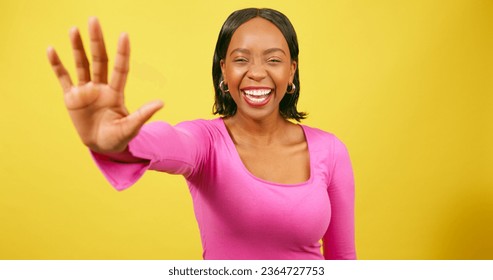 Excited young woman holds up hand, high five close up, yellow studio shoot - Shutterstock ID 2364727753