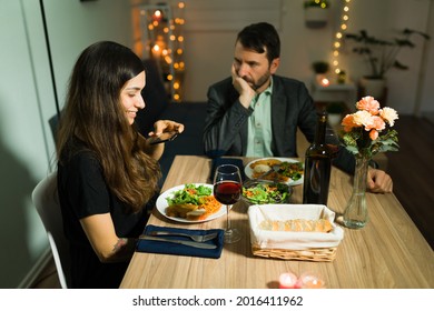 Excited Young Woman Taking A Picture Of Her Delicious Dinner During A Fancy Date At Home With Her Bored Upset Boyfriend