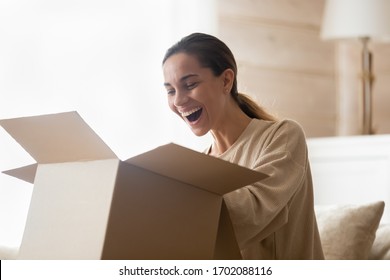 Excited young woman unpacking huge carton box, looking inside. Happy millennial female client satisfied with ordered purchase. Emotional lady surprised by fast delivery service, online shopping. - Powered by Shutterstock