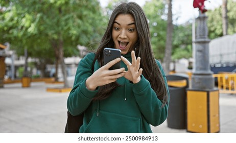 Excited young woman in urban street surprised by smartphone content. - Powered by Shutterstock