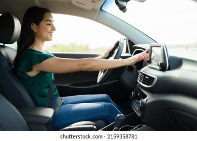 Excited Young Woman Using The GPS In Her Car To Get Directions And Listening To Music On The Radio 