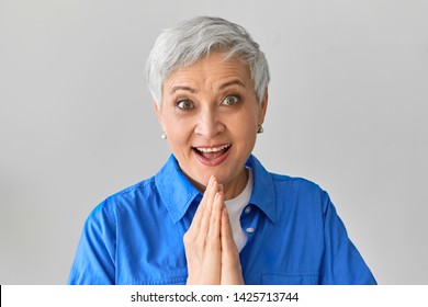 Excitement, Shock, Surprise And Positive Reaction. Emotional Ecstatic Overjoyed Caucasian Female In Blue Shirt Opening Mouth Widely, Being Excited With Spontaneous Trip, Holding Hands Together