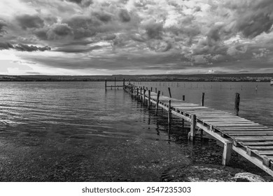 exciting clouds against the sky and lake with a wooden pier  - Powered by Shutterstock