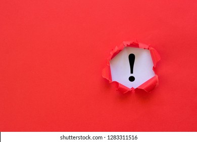 Exclamation mark concept. Torn red paper with exclamation mark on white background.