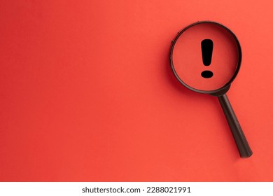 Exclamation mark concept.,Magnifying glass focus on Exclamation mark icon over red background with copyspace for put your text or logo. - Shutterstock ID 2288021991