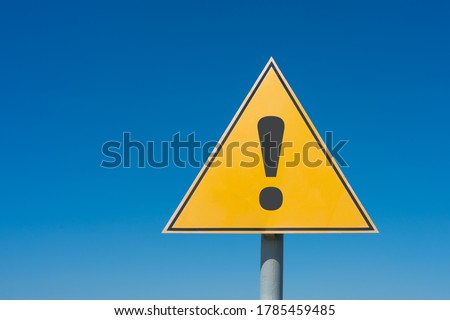 Exclamation mark on a yellow road sign. Against the blue sky Warning, danger, attention