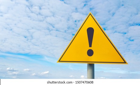Exclamation point of attention against the sky. yellow triangular sign. Danger warning. Attention