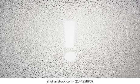 Exclamation sign printed on the wet glass on grey background | warning concept